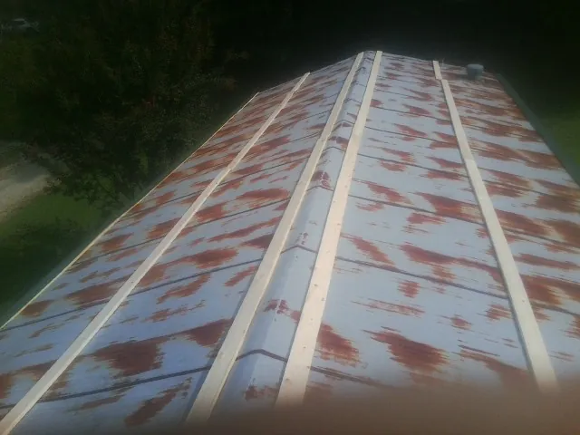 Rusted metal roof panels with new wood purlins before replacement — Storm Damage Roof Repair in Alvin by Roofing Brothers