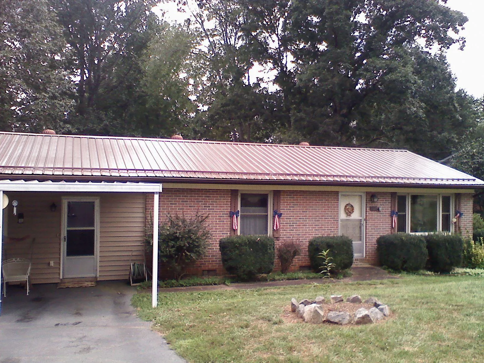 Bronze metal roof and carport on a brick ranch home — Roof Repair work by our crew in Alvin